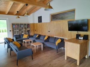 a living room with blue couches and a flat screen tv at Chalet Dumbria Dolomites in Selva di Val Gardena
