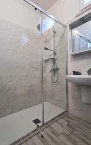 um chuveiro com uma porta de vidro ao lado de um lavatório em Civico 14 Apartment 2 em Monserrato
