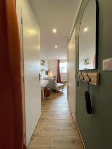 pasillo que conduce a una sala de estar con espejo y pasillo en Magnifique Studio Calais Plage, en Calais