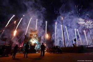 a fireworks display with a statue in the background with people at Magnifique Studio Calais Plage in Calais