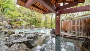 a swimming pool with a waterfall in a backyard at Hotel Yunotaniso in Uonuma