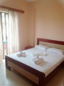 1 dormitorio con 1 cama grande y toallas. en Vila Jakupi, en Sarandë