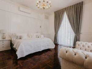 a white bedroom with a bed and a chandelier at Akamah Estate in Cape Town