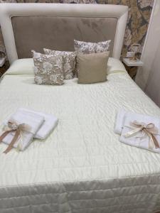 un letto bianco con due asciugamani e cuscini sopra di La Dimora Dei Sogni a Napoli