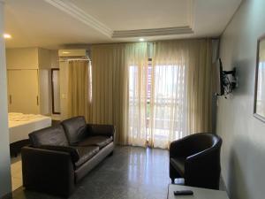 a living room with a leather couch and a chair at Luzon Residence Apartments in Fortaleza