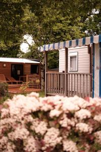 ein kleines Haus mit einer Veranda und einem Zaun in der Unterkunft L'Orée de l'Océan - Vendée in Landevieille
