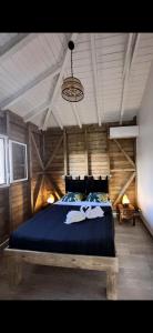 1 dormitorio con 1 cama grande con manta azul en GÎTE de GUADELOUPE en Petit-Bourg