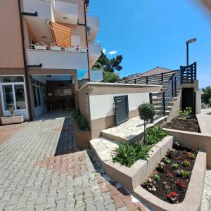 バシュカ・ヴォダにあるApartments Vila Adrijana & Fitness Studio WOLF BVの階段と花の咲く中庭のある建物