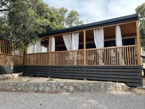 una casa con cortinas blancas en una valla de madera en Luxury Mobile Houses Adria, en Selce