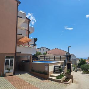 un edificio con piscina di fronte ad esso di Apartments Vila Adrijana & Fitness Studio WOLF BV a Baška Voda
