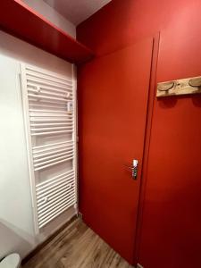 eine rote Tür in einem Zimmer mit WC in der Unterkunft Bel appartement Samoëns 72m2 in Samoëns
