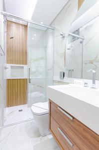 uma casa de banho com um WC, um chuveiro e um lavatório. em Três Quartos, Gigante e confortável Próximo ao Hard Rock Café no Batel em Curitiba
