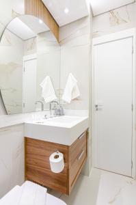 uma casa de banho com um lavatório e um espelho em Três Quartos, Gigante e confortável Próximo ao Hard Rock Café no Batel em Curitiba