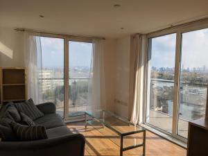 a living room with a couch and a large window at 2 Bed 2 baths Apt in Stratford in London
