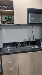 a kitchen counter with a sink and a microwave at Studio Vila Mariana in Sao Paulo