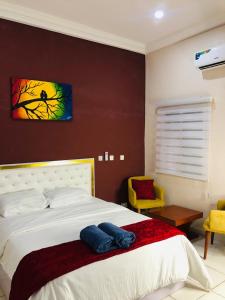 1 dormitorio con 1 cama con una pintura en la pared en Our Nice Home, en Kaduna