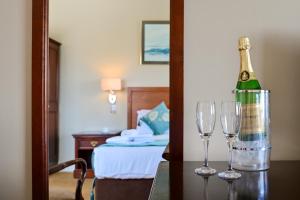 una camera con due bicchieri di vino e una bottiglia sul tavolo di Lawlors Hotel a Dungarvan