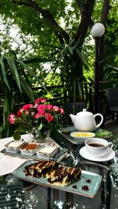 Olympia Garden Hotel في يريفان: طاولة مع أطباق من الطعام وكوب من القهوة