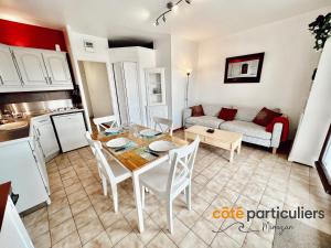 a kitchen and living room with a table and a couch at AU PETIT LOGIS - Apt T1 Bis avec terrasse à 500m de l'Océan in Mimizan