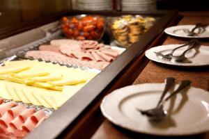 a table with plates and utensils and a tray of food at Sonnenhotel Bayerischer Hof inklusive Eintritt ins AquaFit Erlebnisbad in Waldmünchen