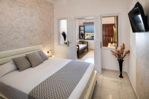 a bedroom with a bed and a living room at Astir Thira Hotel in Fira