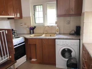 a kitchen with a sink and a washing machine at Nikolas house in Megalochori