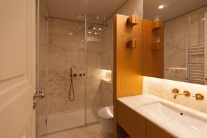 een badkamer met een douche, een wastafel en een toilet bij FLH Praça Rossio Exquisite Apartment with View in Lissabon