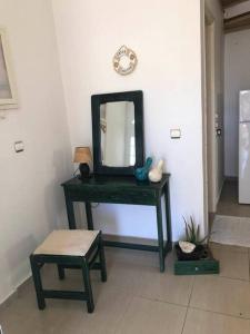 a green dressing table with a mirror and a stool at Nikolas house in Megalochori