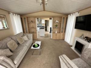 ein Wohnzimmer mit einem Sofa und einem Kamin in der Unterkunft Sunnymede Ingoldmells Keyshare holiday lets in Ingoldmells