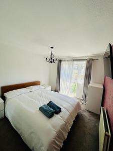 ein Schlafzimmer mit einem weißen Bett mit zwei blauen Handtüchern darauf in der Unterkunft Barnstaple Drive House in Manchester