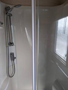 a shower stall in a bathroom with a window at 6 berth holiday home on Ocean Edge near Morecambe in Heysham