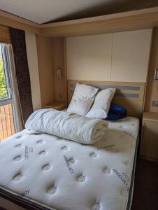 a bed in a room with two pillows on it at 6 berth holiday home on Ocean Edge near Morecambe in Heysham