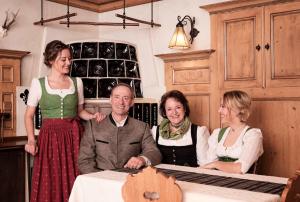 Un groupe de trois femmes et un homme assis à une table dans l'établissement Fiakerhof, à Garmisch-Partenkirchen