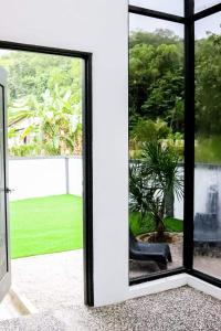 a room with a window looking out at a garden at Tanjung Jara Cottage - with indoor pool in Dungun