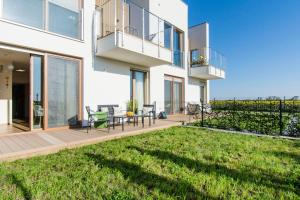 a house with a balcony and a yard at Bursztynowe Tarasy - Apartamenty in Gdańsk