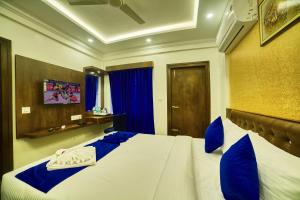 Un dormitorio con una gran cama blanca con almohadas azules. en SM Royal Stay Hotel - Near Bangalore international Airport, en Bangalore 30 fotos más