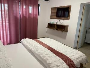 a bedroom with a bed with a tv on the wall at Vila B&P in Costinesti