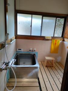 a bath tub in a bathroom with a sink at 農家古民家ねこざえもん奥屋敷 Nekozaemon-Gest house in Nishiwada
