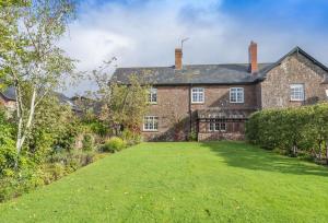 an old brick house with a large yard at Hearn Lodge in Nether Stowey