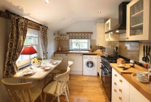 a kitchen with a table and a stove top oven at Lletty in Eglwys-Fâch