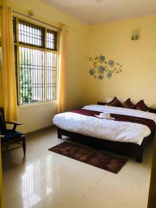 una camera con un grande letto e due finestre di The Emerald House a Varanasi
