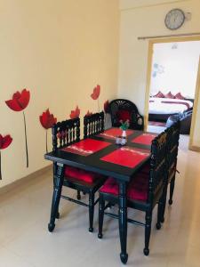 a dining room with a table and chairs with flowers on the wall at The Emerald House in Varanasi
