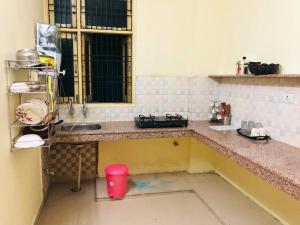 uma cozinha com um lavatório e um balcão com um copo vermelho em The Emerald House em Varanasi