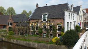 a group of houses next to a river at B&B Ferdivedaasje in Dokkum