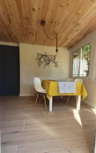 een eetkamer met een gele tafel en stoelen bij Appartement dans Mas Provençal in Châteaurenard