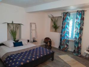 een slaapkamer met een bed en een raam met gordijnen bij Appartement dans Mas Provençal in Châteaurenard