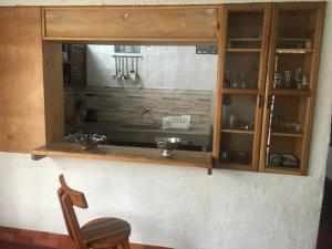 a kitchen with a wooden cabinet and a chair at Casa típica de la Región del Café in Calarcá