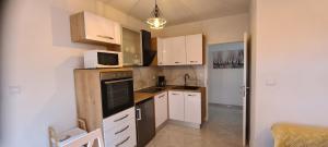 una piccola cucina con armadietti bianchi e forno a microonde di Apartments Orlić a Sali (Sale)