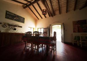 a dining room with a table and chairs in a room at Hostal La Albahaca in Tilcara