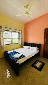 - une chambre avec un grand lit dans l'établissement Navile Apartments, à Chikmagalur